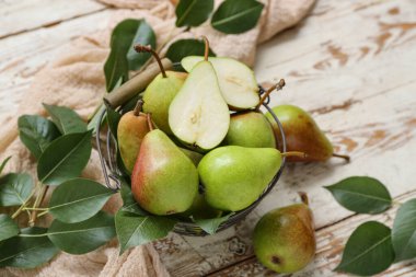 Tahta masada olgun armutlarla dolu sepet, yakın plan.