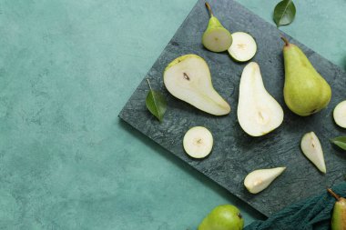 Dilimlenmiş armut ve yeşil masa.