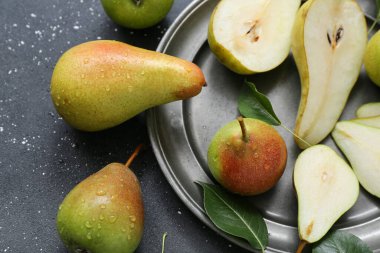 Siyah masada olgun armutlarla kaplanmış, yakın plan.