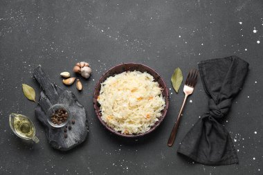 Lezzetli lahana turşulu kase ve siyah arka planda farklı baharatlar.