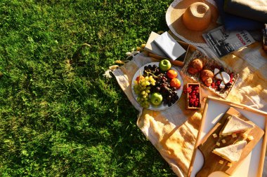 Romantik pikniğe hazır, yeşil çimlerin üzerinde lezzetli yemekler var.