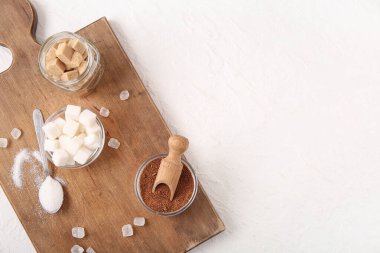 Beyaz zemin üzerinde farklı tipte şeker bulunan ahşap tahta.