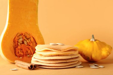 Çekirdekli lezzetli balkabağı krepleri ve turuncu arka planda tarçın