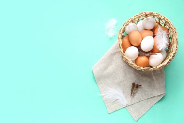 Turkuaz arka planda çiğ tavuk yumurtası ile hasır kase.