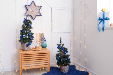 Parlayan ışıkları, köknar ağaçları ve geleneksel Hanuka süslemeleri olan festival salonu.