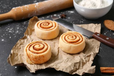 Siyah arkaplanda pişmemiş tarçın ruloları