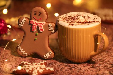 Bir fincan sıcak kakaolu zencefilli kurabiye ve grunge masasının üzerinde bulanık bir arkaplan.