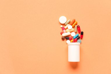 Şişeli kompozisyon ve renkli arka planda haplar