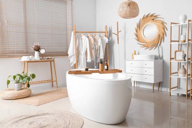 Banyonun içinde altın ayna, lavabo ve küvet var.