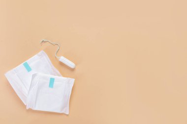 Bej arka planda tampon olan adet pedleri