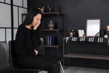 Mourning young Asian woman crying at funeral clipart