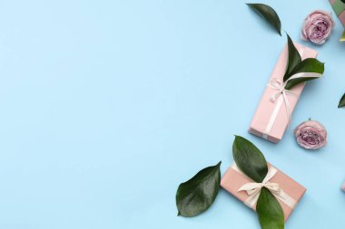 İçinde güzel güller ve mavi arka planda yapraklar olan hediye kutuları. Uluslararası Kadınlar Günü