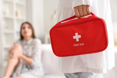 Travma geçiren kadının yatak odasında ilk yardım çantası olan doktor, yakın plan.