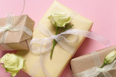 Pembe arka planda güzel beyaz güller olan hediye kutuları. Uluslararası Kadınlar Günü