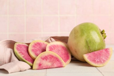 Olgun karpuz turpları beyaz fayans masasında.