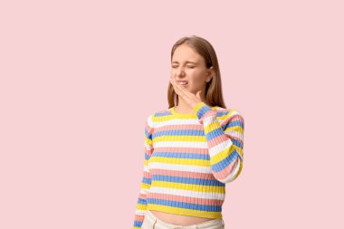 Genç bir kadın pembe arka planda iğrenç bir koku hissediyor.