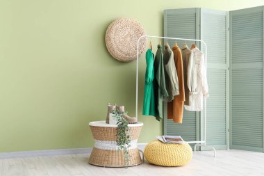 Kadın giysileri ve katlanan perdesi olan modern odanın şık bir iç mekanı.