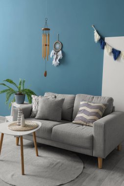 Oturma odasının içinde rüzgar çanı, düş kapanı ve kanepe