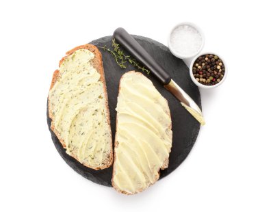 Beyaz zemin üzerinde taze tereyağı, biber ve tuz ile siyah ekmek dilimleri