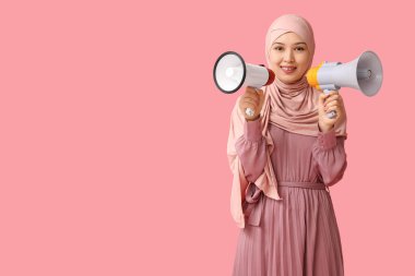 Pembe arka planda megafonları olan genç Asyalı Müslüman kadın. Ulusal Duyulma Günü