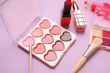 Eflatun arka planda dekoratif kozmetik seti