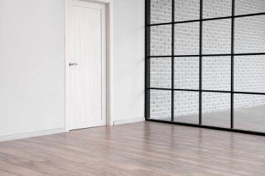 Kapısı, katlanır ekranı ve ahşap kaplaması olan boş bir oda görüntüsü