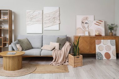 Rahat kanepesi, sehpası ve resimleri olan bir ışık odası.