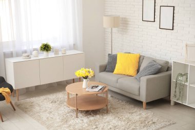 Oturma odasının iç tarafında yastıkları ve kahve masası olan rahat bir kanepe.