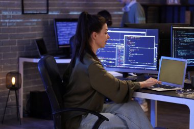 Geceleri bilgisayarla çalışan kadın programcı.