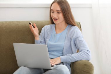 Female tutor with laptop giving online lesson at home