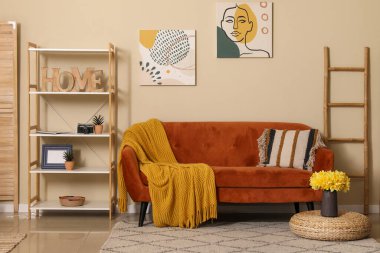 Kareli kanepe, yastık ve vazoyla oturma odasında narsist çiçekler.