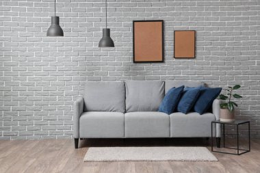 Güzel, şık bir oda, rahat bir kanepe, halı ve çiçekli.