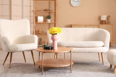 Oturma odası, kanepe, koltuk ve nergis çiçekleri.