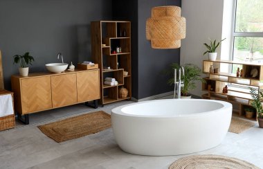 Küvetli, ahşap mobilyalı ve çiçekli modern banyo.