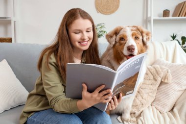 Evde şirin bir Avustralya çoban köpeği dergisi olan genç bir kadın var.