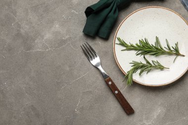 Gri grunge arka planda peçete, çatal ve biberiye ile şık masa ayarları