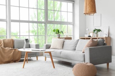 Masasında modern aletler ve kanepelerle aydınlık oturma odasının içinde.