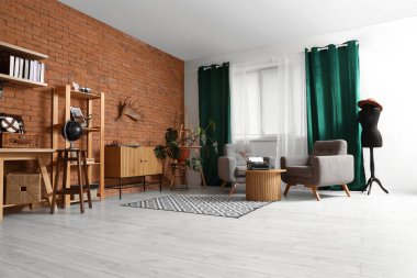 Oturma odasının içinde koltuklar ve masanın üzerinde klasik daktilo var.