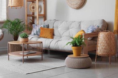 Rahat kanepesi, sehpası ve çiçekleri olan güzel bir oturma odası.