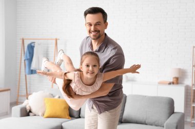 Baba ve küçük kızı oturma odasında birlikte oynuyorlar. Babalar günü kutlaması.