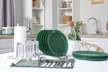 Mutfaktaki yemek masasında temiz tabaklar ve bardaklar.