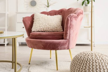 Kahve masasının yanında minderli koltuk ve oturma odasında puf.