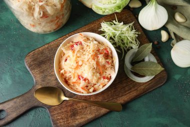 Lezzetli lahana turşusu ve yeşil arka plandaki malzemeler. Üst görünüm