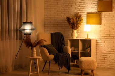 Raflarda parlayan lamba, şık oturma odasında yumuşak koltuk ve kahve masası.