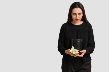 Morg vazosu ve beyaz arka planda zambak çiçeği olan genç bir kadın.