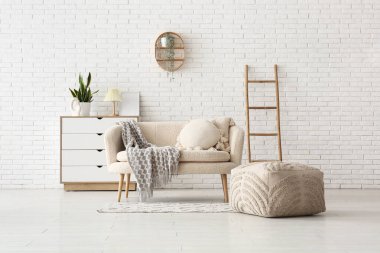 Ekoseli rahat kanepe, çekmeceler ve oturma odasında puf.