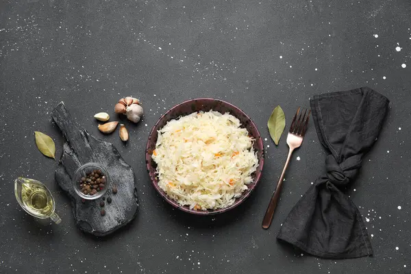 Lezzetli lahana turşulu kase ve siyah arka planda farklı baharatlar.