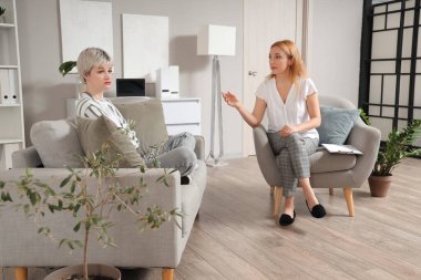 Ofiste üzgün genç bir kızla çalışan kadın psikolog.