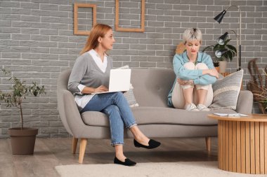 Dizüstü bilgisayarı olan kadın psikolog ve ofisteki sinirli genç kız.