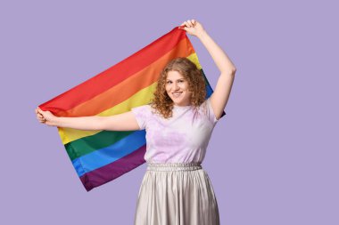 Beautiful young woman with LGBT flag on lilac background
